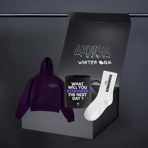 An open black gift box holding a hoodie, a mug and a sock.